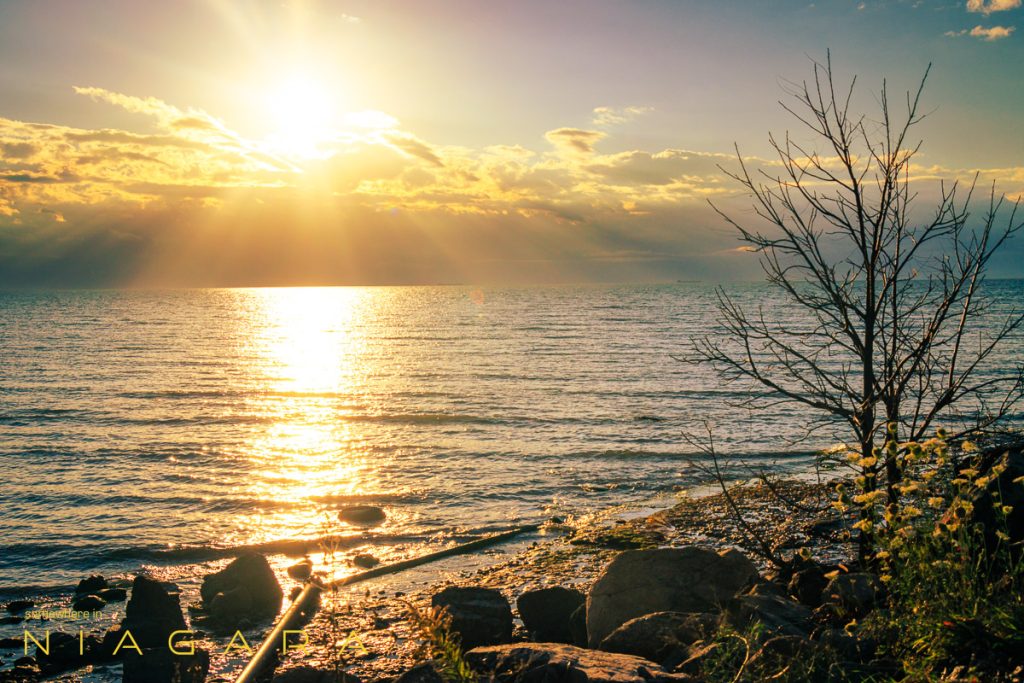 Sun over Lake Erie as waves lap the beach