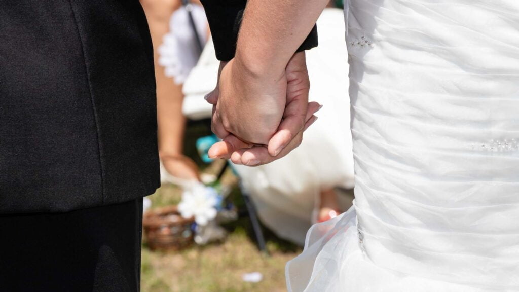 Bride and groom holding hands.
