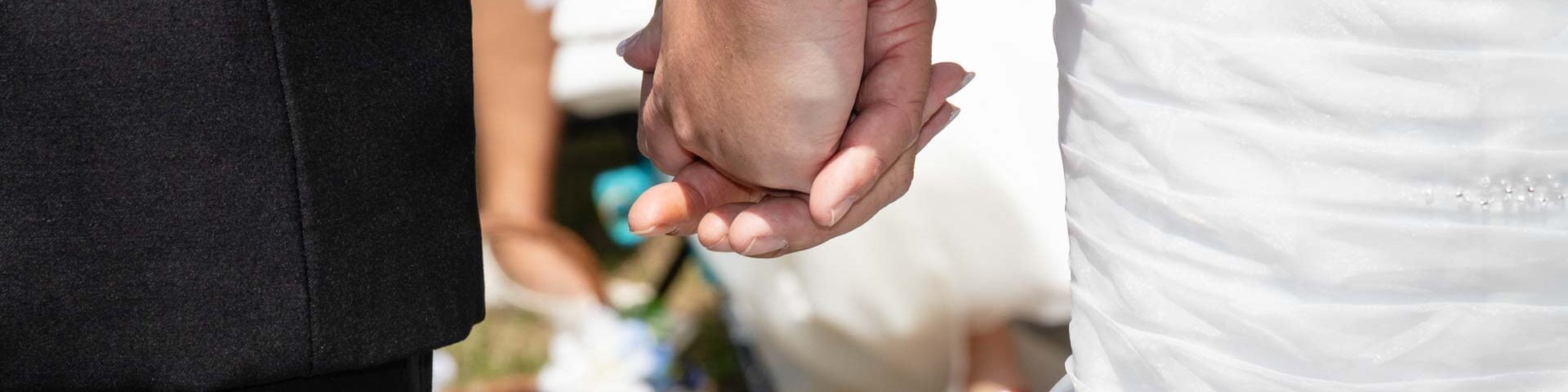Bride and groom holding hands.