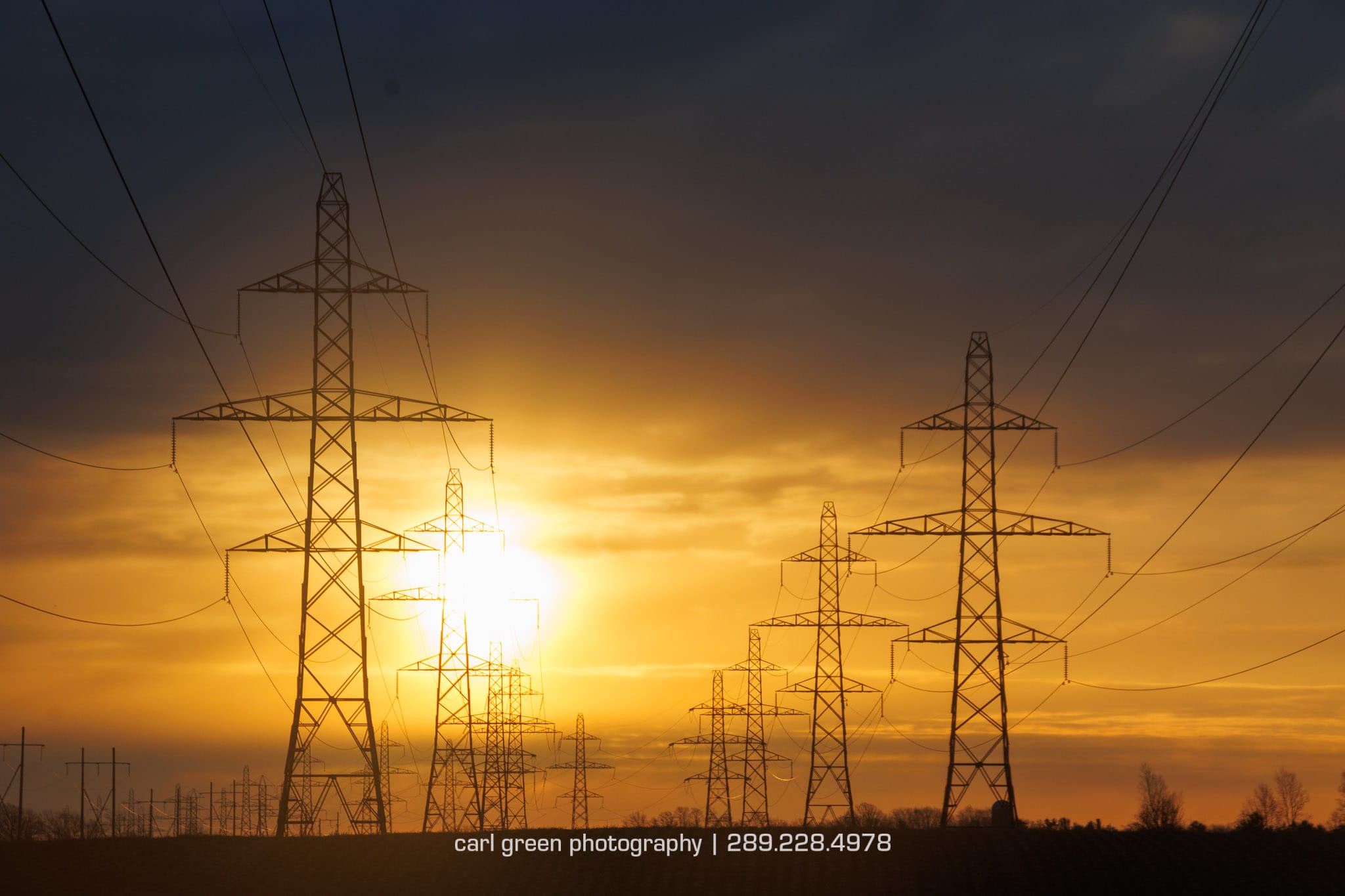 Sunrise over symmetrical electrical pylons